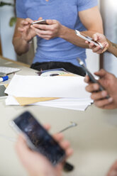 Kollegen nutzen Smartphones im Büro - FKF001813