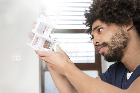 Junger Mann begutachtet Architekturmodell, lizenzfreies Stockfoto