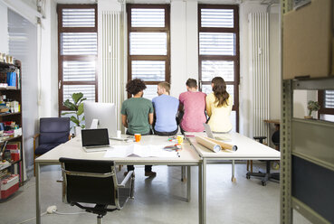 Ein Team von Kreativprofis sitzt am Schreibtisch im Büro - FKF001824