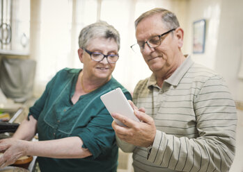 Älteres Paar schaut zu Hause auf sein Smartphone - EPF000068