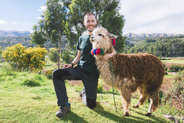 Peru, Cusco, Porträt eines glücklichen Touristen, der mit einem Lama posiert - GEMF000860