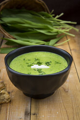 Bowl of bear's garlic soup and fresh ramson leaves in the background - LVF004748