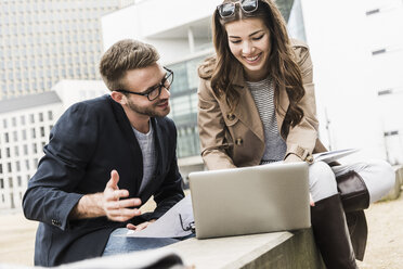 Young business couple working together outdoor, using laptop - UUF006889