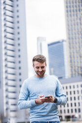 Junger Mann in der Stadt mit Smartphone - UUF006896