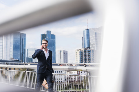 Junger Geschäftsmann beim Spaziergang in der Stadt, lizenzfreies Stockfoto