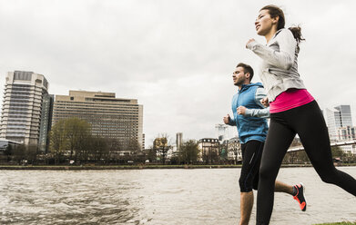 Junges Paar joggt am Fluss - UUF006956