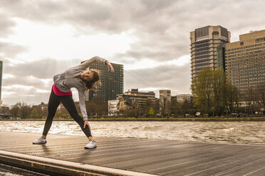 Young woman stretching at the riverseide - UUF006959