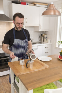 Mann bereitet Espresso in der Küche zu - BOYF000260