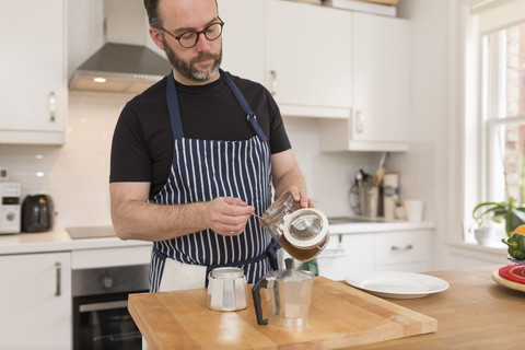 Mann bereitet Espresso in der Küche zu, lizenzfreies Stockfoto