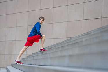 Young jogger stretching on steps - DIGF000260