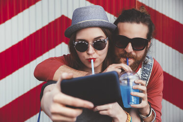 Young couple with soft drinks taking selfie with smartphone - RTBF000112