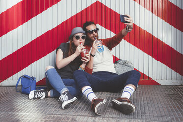 Junges Paar mit alkoholfreien Getränken macht Selfie mit Smartphone - RTBF000115