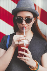 Porträt einer jungen Frau mit Hut und Sonnenbrille, die ein Erfrischungsgetränk trinkt - RTBF000117
