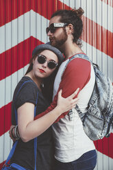 Young couple wearing sunglasses embracing on the street - RTBF000119