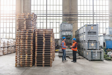 Two men talking in factory hall - DIGF000296