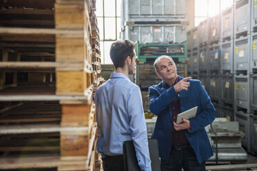 Manager talking to colleague between pallets - DIGF000297