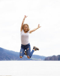 Austria, portrait of happy teenage girl jumping in the air - WWF003939