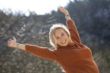 Portrait of happy teenage girl with raised arms - WWF003942