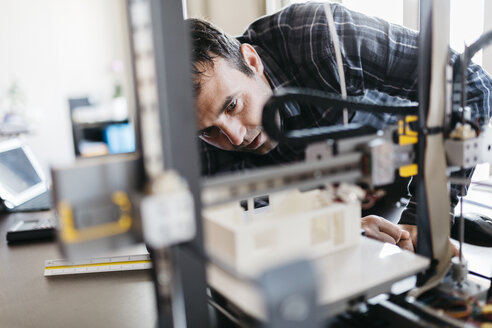 Arbeiter, der ein Modell kontrolliert, 3D-Drucker - JRFF000543
