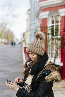 UK, London, Notting Hill, young woman looking at her smartphone - MGOF001721