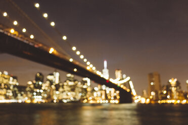 USA, New York City, blurred skyline and Brooklyn Bridge at night - GIOF000888