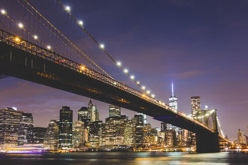 USA, New York City, lighted skyline and Brooklyn Bridge in the foreground at night - GIOF000889