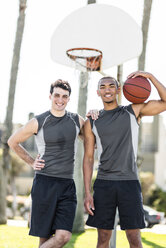 Porträt von zwei lächelnden jungen Männern auf einem Basketballplatz im Freien - LEF000116