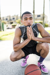 Basketball player crouching on outdoor court - LEF000118