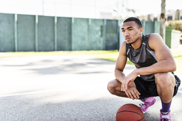 Basketball player crouching on outdoor court - LEF000120