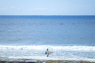 Spanien, Teneriffa, Junge mit Surfbrett im Meer - SIPF000357