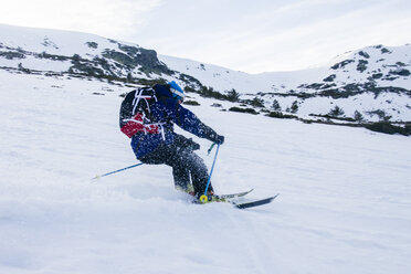 Mann beim Skifahren in einer verschneiten Berglandschaft - ABZF000360