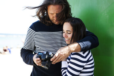 Spain, Barcelona, couple wearing striped sweaters looking at camera - VABF000451