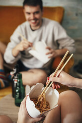 Junges Paar isst chinesisches Essen zum Mitnehmen zu Hause - RTBF000140