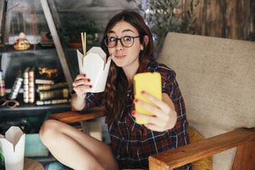 Young woman taking a selfie with her Chinese takeaways. - RTBF000141