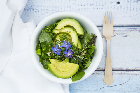 Detox Bowl of different lettuces, vegetables, cress, quinoa, avocado and starflowers stock photo