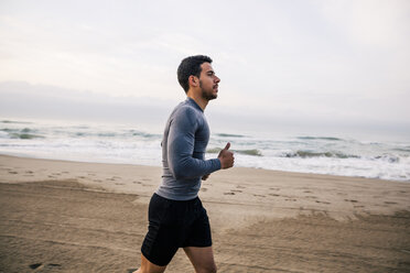 Young man running on the beach - EBSF001297