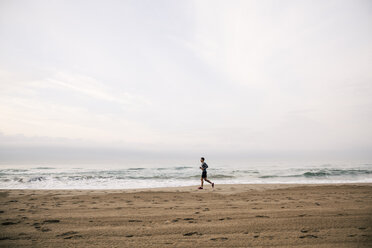 Junger Mann läuft am Strand - EBSF001298