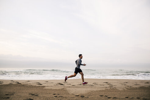 Young man running on the beach - EBSF001299