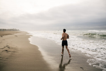 Junger Mann läuft am Strand - EBSF001306