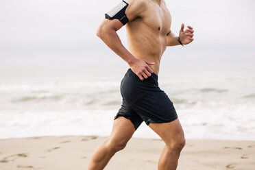 Young man running on the beach - EBSF001308