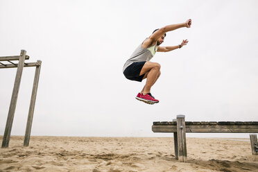 Junger Mann springt am Strand - EBSF001341