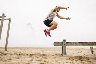 Junger Mann springt am Strand - EBSF001342