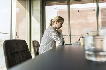 Young woman at desk in office with closed eyes - UUF006962