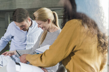 Three colleagues looking at plan in office - UUF006970