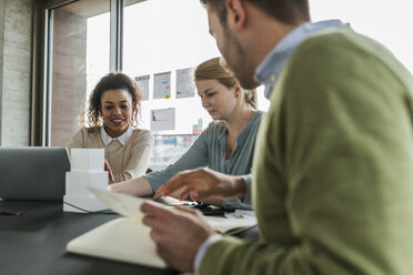 Drei Kollegen im Büro arbeiten zusammen - UUF006981