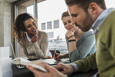 Three colleagues in office working together - UUF006985