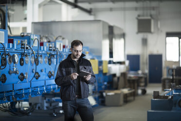 Junger Techniker bei der Arbeit mit einem Tablet-PC - SGF002028