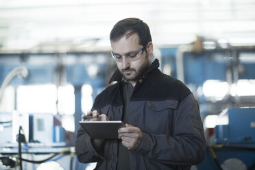 Junger Techniker bei der Arbeit mit einem Tablet-PC - SGF002029