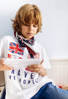 Porträt eines coolen Jungen, der zu Hause ein digitales Tablet benutzt - MGOF001758