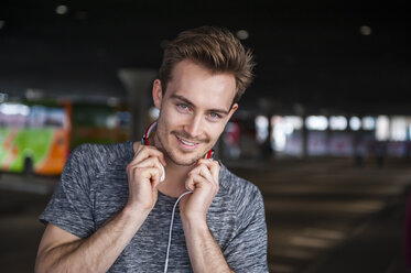 Portrait of smiling young man with headphones - DIGF000333